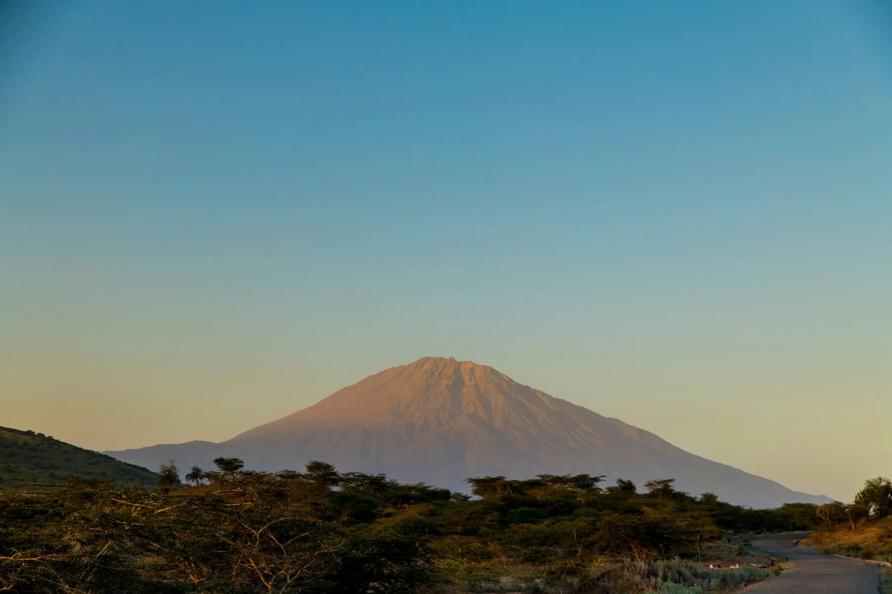 Mount Meru rising above the Arusha landscape at sunset