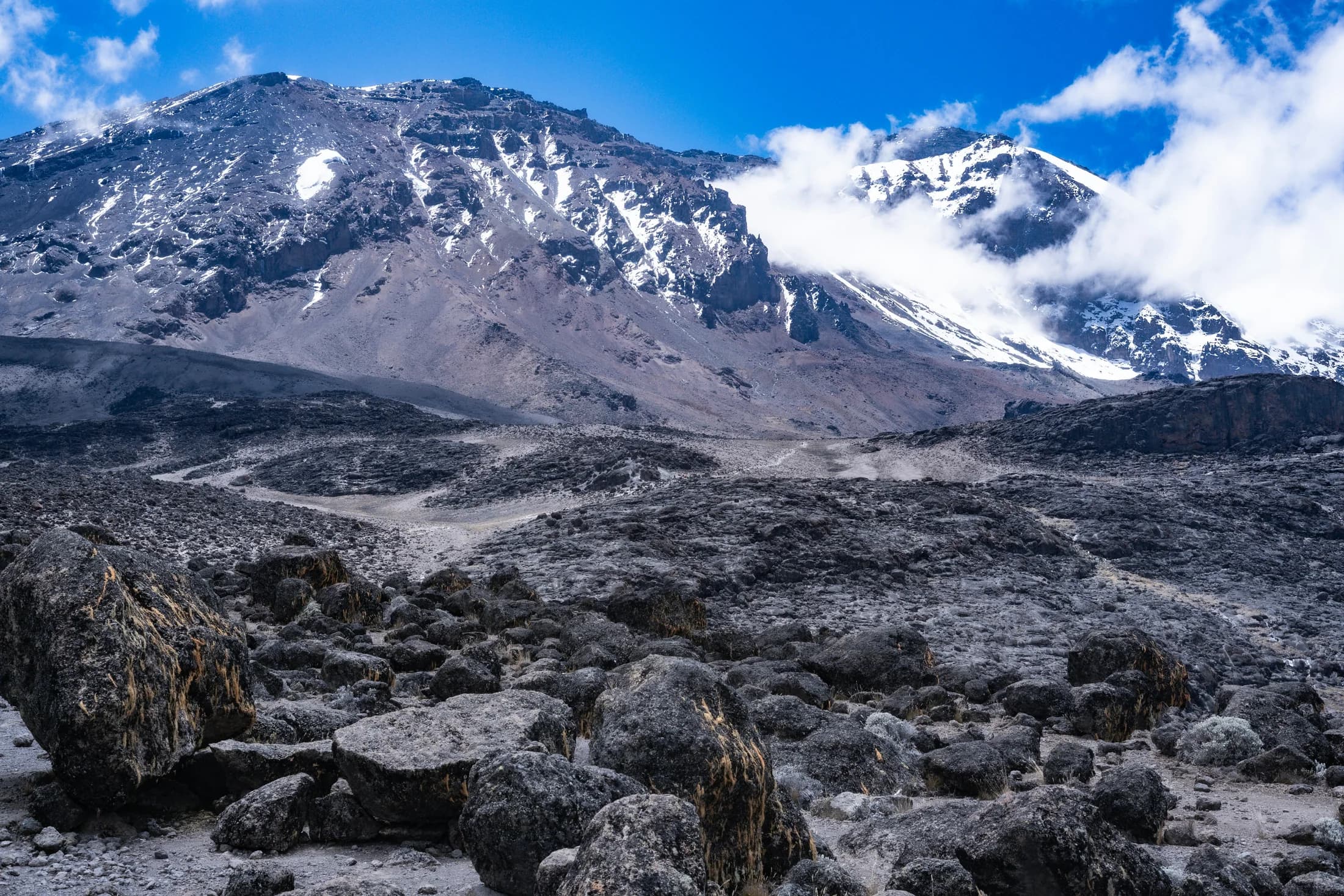 Rocky terrain below Kilimanjaro’s snow-covered upper slopes